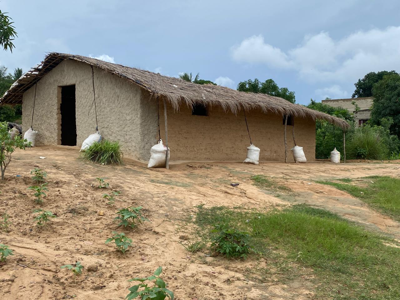 Casa de adobe com sacos de produção agrícola